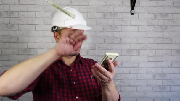 Retrato de um homem alegre em um capacete de construção jogando dinheiro . — Vídeo de Stock