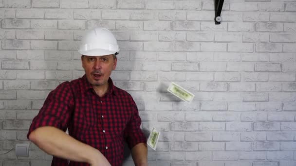 Retrato de um homem alegre em um capacete de construção jogando dinheiro . — Vídeo de Stock