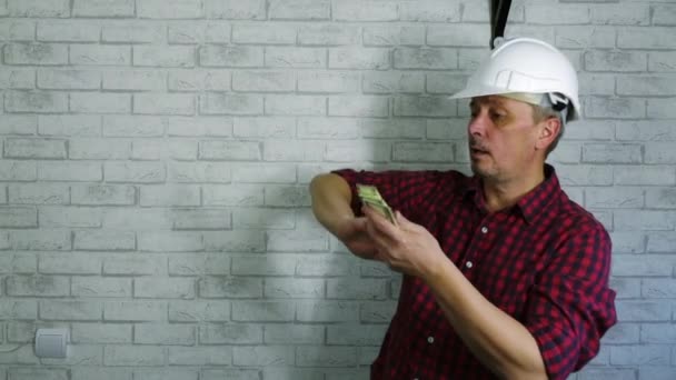 Ritratto di un uomo allegro in un casco da costruzione gettare soldi . — Video Stock