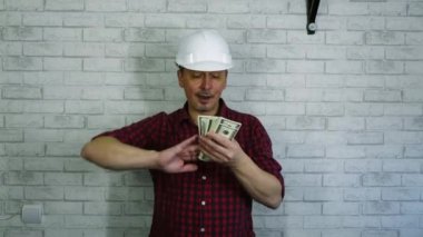 İnşaat kaskı takmış, para saçan neşeli bir adamın portresi .