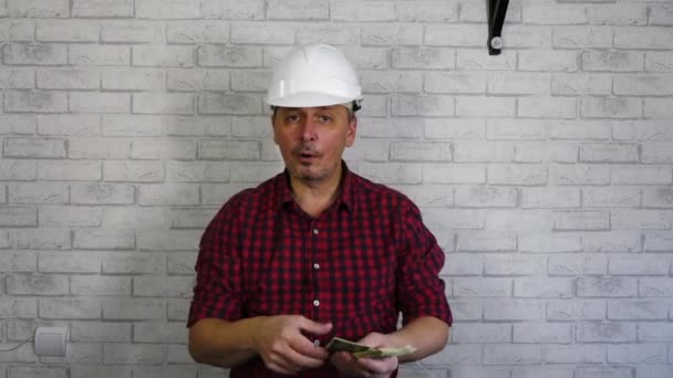Portrét veselého muže ve stavební helmě házejícího peníze . — Stock video