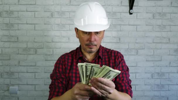 一个戴着建筑头盔的快乐男人抛钱的画像 . — 图库视频影像