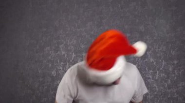 Noel Baba şapkalı bir adam komik dans ediyor..