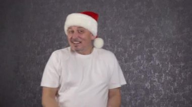 Noel Baba şapkalı bir adam komik dans ediyor..