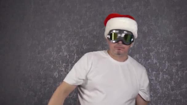 Een man met een kerstmuts danst grappig.. — Stockvideo