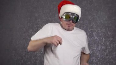 Noel Baba şapkalı bir adam komik dans ediyor..