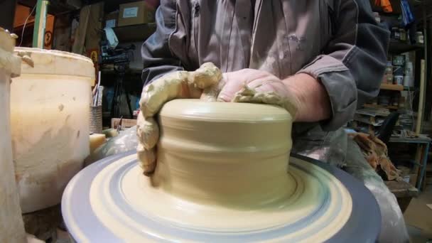 A male potter on a potters wheel makes a ceramic jug of clay. — Stock video