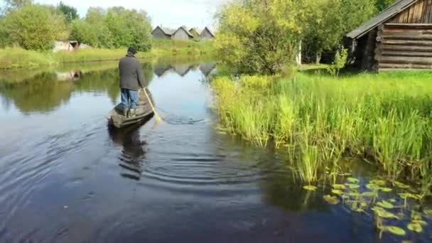 A view from a drone of a man floating on a rowing boat on the river. — Vídeo de Stock