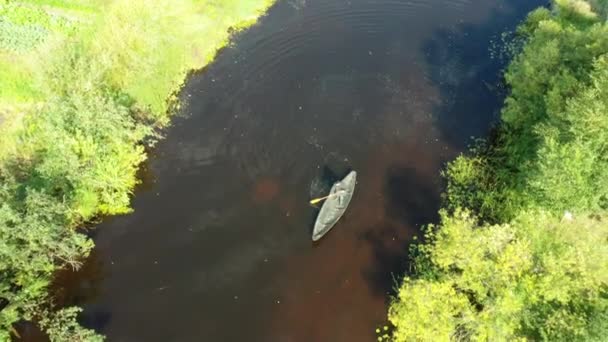 A view from a drone of a man floating on a rowing boat on the river. — Stock video
