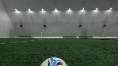 Fotokopi alanı olan yeşil çimlere yerleştirilmiş bir futbol topu..