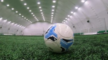 Fotokopi alanı olan yeşil çimlere yerleştirilmiş bir futbol topu..