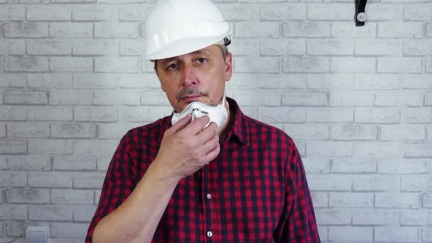 Портрет человека в строительном шлеме и респиратор на лице. — стоковое видео