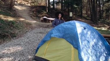Genç bayan yürüyüşçü ormanda kumaştan yapılmış bir çadır kurdu..