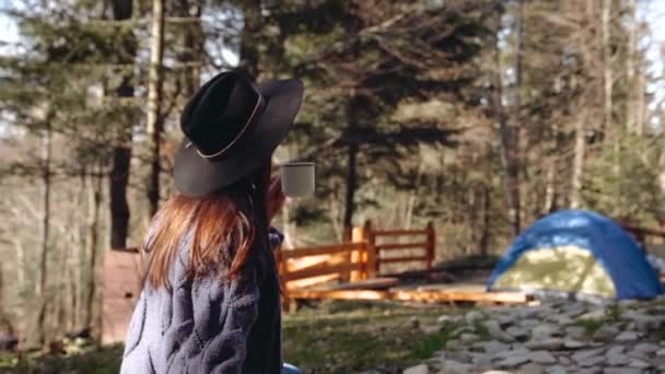Jente i skogen og plukker opp en kopp kildevann utendørs og drikker – stockvideo
