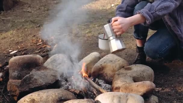 Traveler woman pours itself hot coffee next to bonfire — Stock Video
