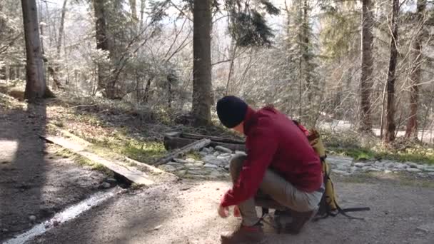 Ten chlap uvázal tkaničky na hnědé boty, stojící na jednom koleni na zemi.. — Stock video