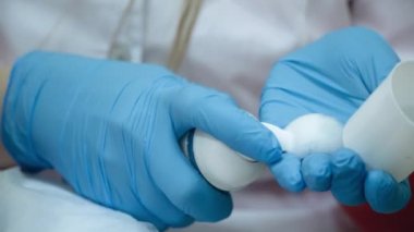 Eldivenli güzellik doktoru yüz temizleme köpüğü sürüyor. 