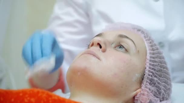 Αισθηματολόγος κάνει μια γυναίκα μια θεραπευτική διαδικασία σε ένα πρόσωπο. — Αρχείο Βίντεο