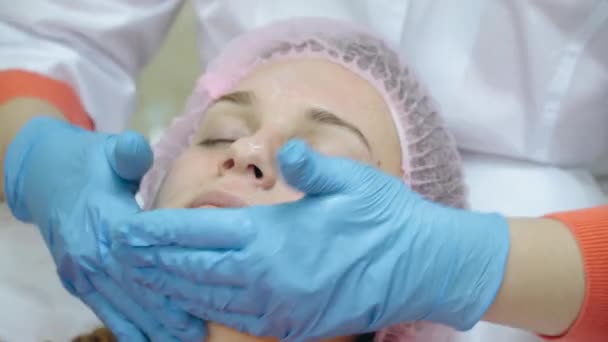 Médico en guantes médicos azules frota espuma en la máscara de gel facial — Vídeos de Stock