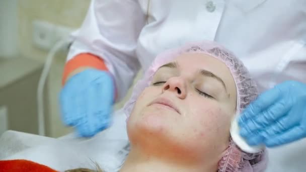Crema limpiadora esteticista con almohadillas de algodón anestésico de cara de niña — Vídeo de stock
