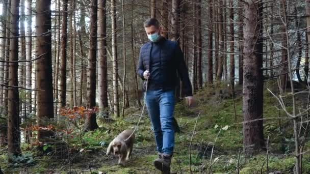 Молодой человек гуляет с собакой Кокер Спаниель в лесу. — стоковое видео