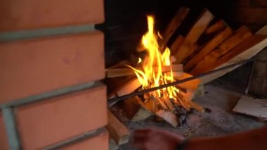 Bir adam odunları ateşe veriyor. Ateş ormanları. Eller yukarı. Ateşin üzerindeki kütükler. Şömineyi yemek için hazırlıyorum. Yüksek kaliteli FullHD görüntüler