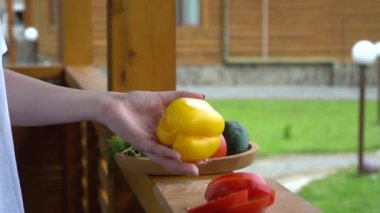 Tahtasında bıçak olan kız olgun sarı dolma biber kesiyor. Yüksek kaliteli FullHD görüntüler