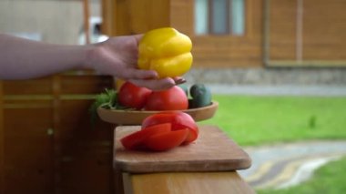 Tahtasında bıçak olan kız olgun sarı dolma biber kesiyor. Yüksek kaliteli FullHD görüntüler