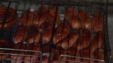 Kızarmış lezzetli sosisler ateşte ızgarada kızartılmış. Yüksek kaliteli FullHD görüntüler