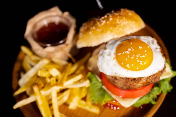 Close-up of beef burger with fried egg on white background. Hamburger - bun, grilled meat burger, lettuce, tomato and fried egg. High quality photo