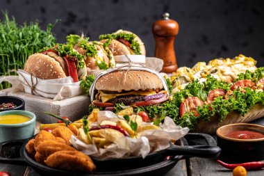 Sığır eti, domates, peynir, pastırma ve marullu ev yapımı lezzetli hamburgerler. Fast food ve abur cubur kavramı.