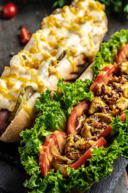 Gurme sosisli sandviçleri çeşitli malzemelerle ızgara yaptı. dikey görüntü. en üstteki görünüm.