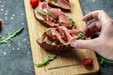 Lezzetli bruschetta ahşap tahta servis ediyordu. Antipasto Yemeği ya da aperatif parti konsepti.