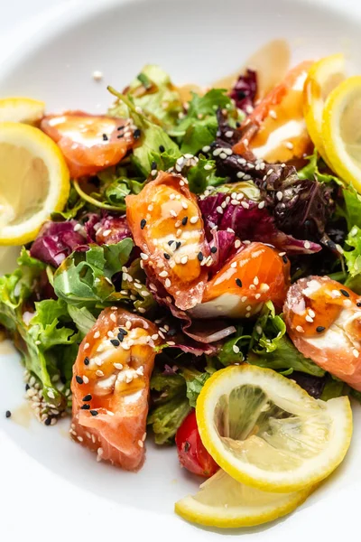 Salmon fish salad. Fresh vegetable lettuce and salmon fish fillet, healthy food, omega 3, keto diet, mediterranean cusine, top.