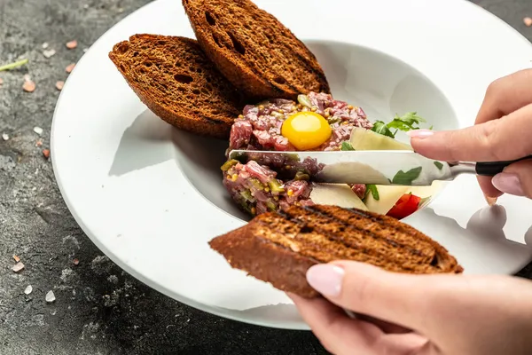 Yumurtalı sığır eti, soğan, taze otlar, ekmek. Fransız mutfağı. Yemek tarifi geçmişi. Kapat..