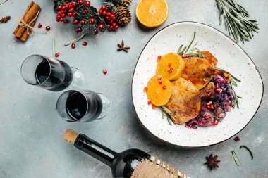 Kızarmış kaz bacağı, portakal ve şenlik masasında kırmızı lahana. Noel zamanı yemek pişirmek. afiş, menü, metin için tarif yeri, üst görünüm.