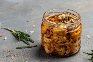 Zeytinyağlı ve baharatlı biberiyeli peynirli cam kavanoz. pankart, menü, tarif.