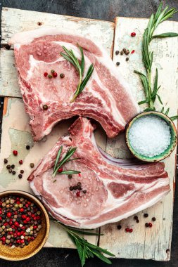 Baharatlı ve biberiyeli taze çiğ et. Domuz eti, sığır eti, pirzola. dikey görüntü. Üst Manzara. metin için yer.