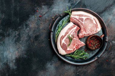 Metal tepside çiğ domuz bifteği kızartma için hazır. Kemik doğra. metin için yer, üst görünüm.