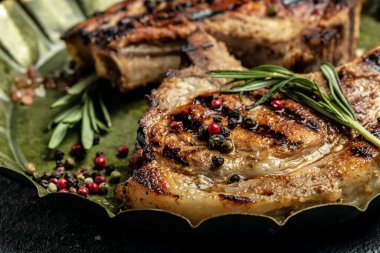 Metal tepside baharatla servis edilen ızgara domuz filetosu. Uzun afiş biçimi. en üstteki görünüm.