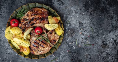 Kızarmış patates ve domatesli ızgara domuz pirzolası. afiş, menü, metin için tarif yeri, üst görünüm.