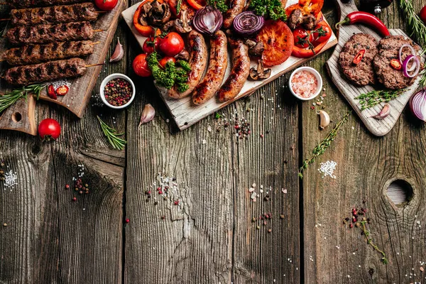 Grilled meat and vegetables on wooden table. Barbecue menu. banner, menu, recipe place for text, top view.