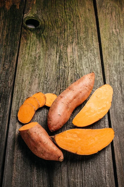 Organic orange sweet potato. Raw sweet potatoes or batatas. vertical image. top view. place for text.