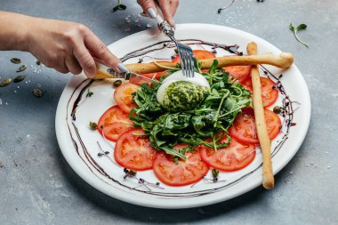 İtalyan burrata peynirli salata, domates, taze roka ve yeşil pesto, vejetaryen italyan yemeği. en üstteki görünüm.