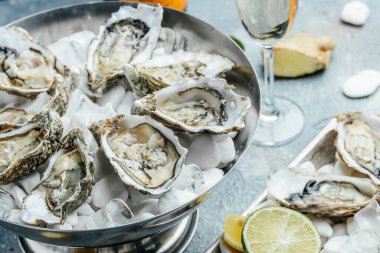 Restoranda buz, limon ve şampanya ile metal tepside istiridye. Restoran menüsü, diyet, yemek kitabı tarifi..