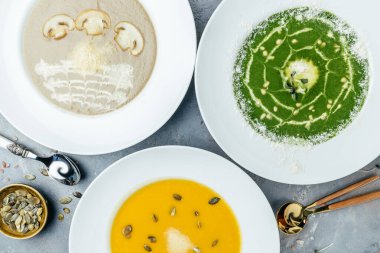 Üç çorbadan oluşan büyük bir yemek seti, menü hazır. Vejetaryen çorbası. Kabak ve havuç çorbası, brokoli kremalı çorba ve mantar çorbası. en üstteki görünüm.