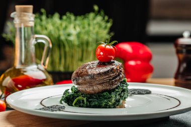 Ispanakla servis edilen lezzetli sığır eti madalyonları. Sağlıklı yağlar, kilo vermek için temiz yiyecekler..