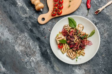 Biftekli salata. Az pişmiş biftek, ızgara sebze, fındık ve sos. afiş, menü, metin için tarif yeri, üst görünüm.