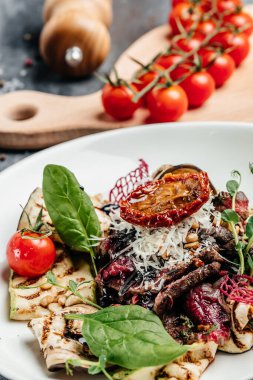Salata dilimlenmiş biftek barbeküsü ızgara sebze, fındık, sos ve parmesan peyniri. İtalyan mutfağı konsepti. dikey görüntü. en üstteki görünüm.