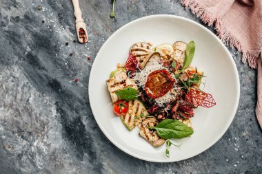 Domatesli salata, orta boy biftek, ızgara sebze, fındık, sos ve parmesan. Taze Sulu orta pişmiş mermer et ızgara biftek. afiş, menü, metin için tarif yeri, üst görünüm.